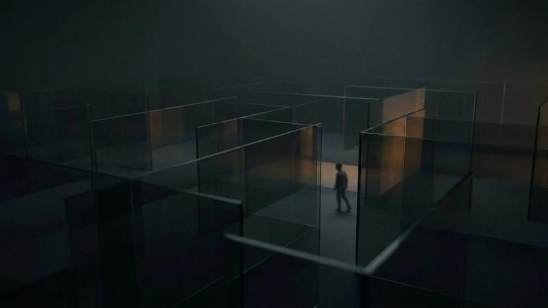 A person walks through a dimly lit maze of transparent walls, casting soft shadows. The atmosphere is mysterious and moody.