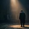 Dark cinematic scene of a lone man standing under a narrow beam of light inside a vast shadowy hall, creating a moody and introspective atmosphere.
